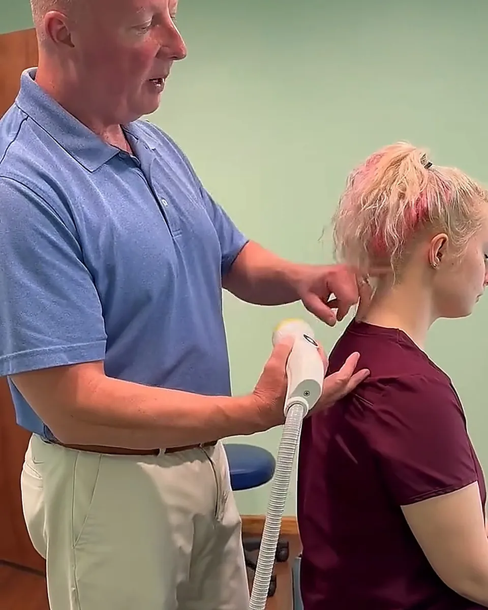 Dr. Matt Chenault treating a patient's shoulder with SoftWave therapy at Greenville Rehab and Pain Clinic